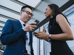 A man and woman looking at a phone and smiling.