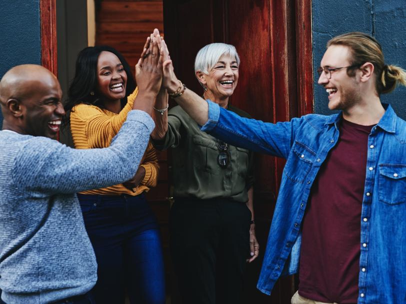 Group of people giving each other high-fives.